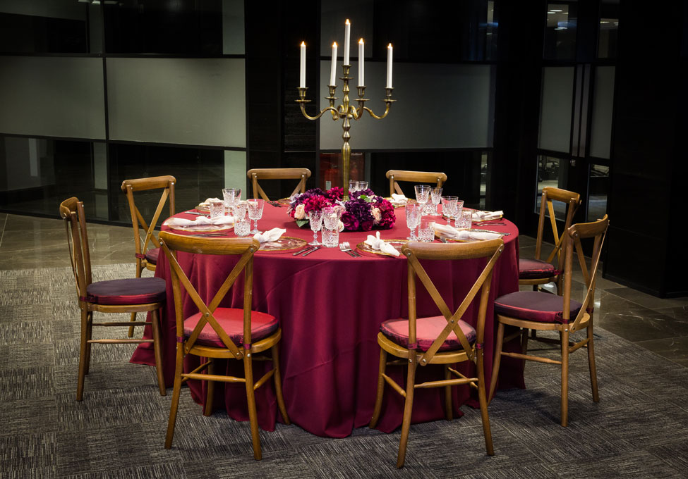 Styling featuring Wine Essential table linen, Gold Trim charger plates with Biscuit Essential napkins, Crossback Chairs with Burgundy Taffeta seat pads, Cut Crystal glasses and Rustic Bronze Candelabra