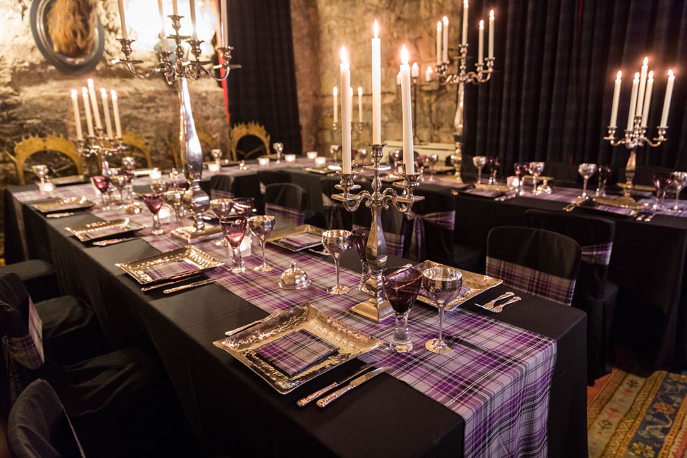 Black Essential table linen and chair covers paired with Ailsa Tartan set ties, Pewter charger plates with Ailsa Tartan napkin,Purple Chalice and Pewter Goblet, Silver Square Base Candelabra