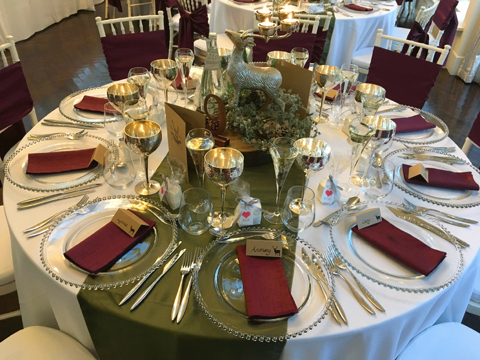 White Essential table linen, Woodland Taffeta runners,Silver Beaded charger plates paired with Plum Faux Silk napkins and Ivory Chiavari Chairs with White Essential Cushioned Seat Pads and Plum Faux Silk seat ties