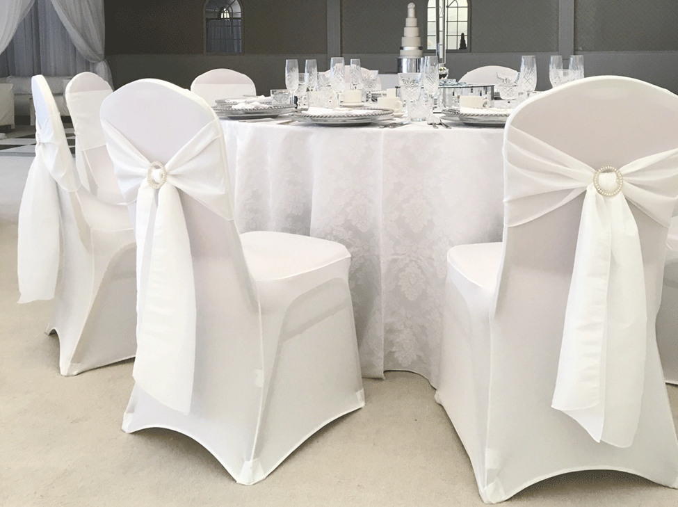 Snow White Vintage Damask table linen, White Italian Stretch Chair Covers paired with Cloudy White taffeta seat ties styled with diamante buckles