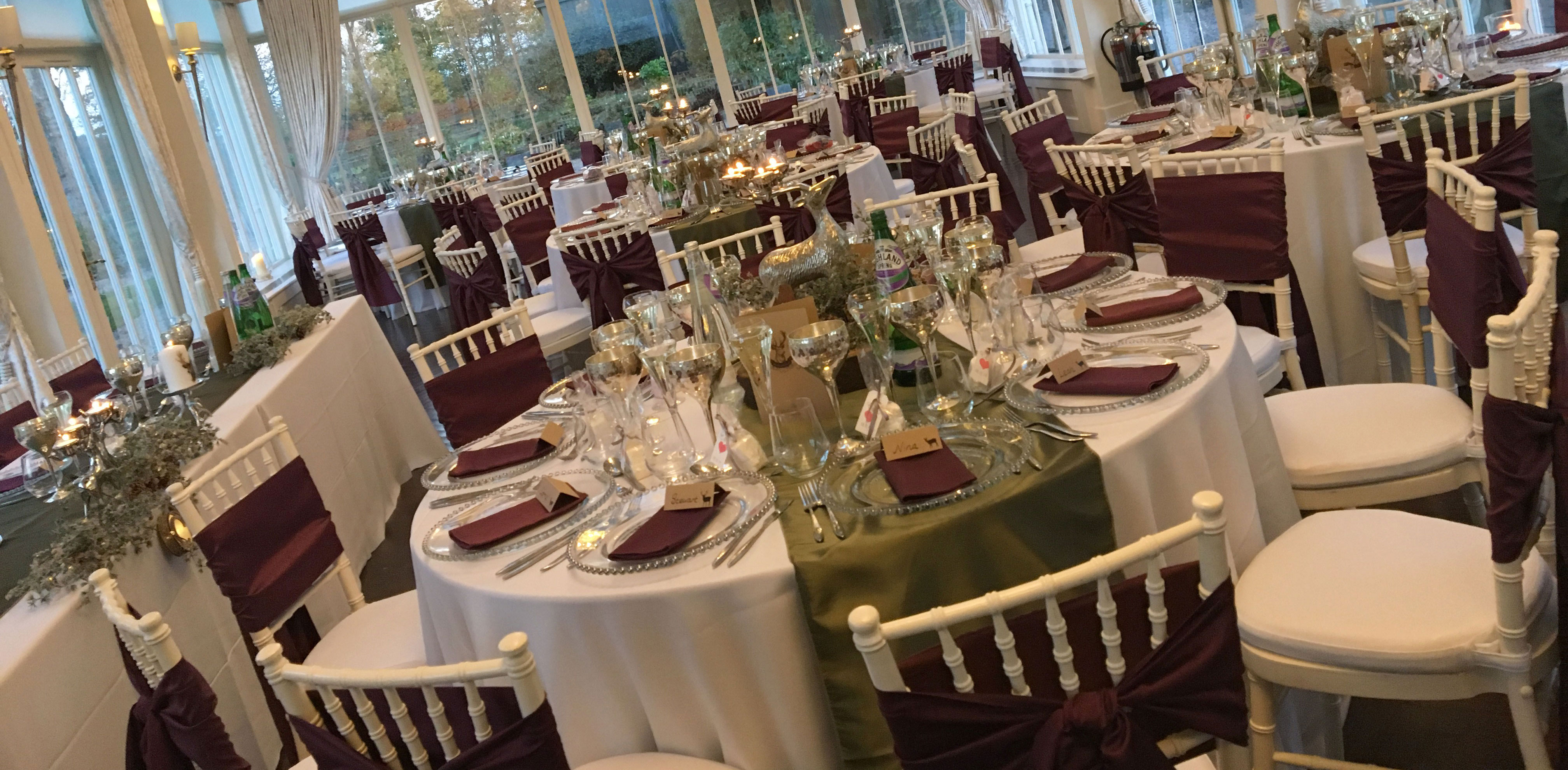 White Essential table linen, Woodland Taffeta runners,Silver Beaded charger plates paired with Plum Faux Silk napkins and Ivory Chiavari Chairs with White Essential Cushioned Seat Pads and Plum Faux Silk seat ties