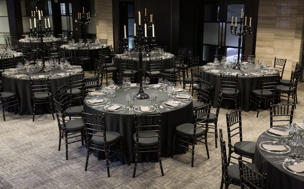 Black Essential table linen, Black Chiavari Chiars with Black Essential seat pads, Graphitee Gelato napkins paired with Silver Beaded charger plates, Smoke Grey glasses and Black Gloss Candelabras