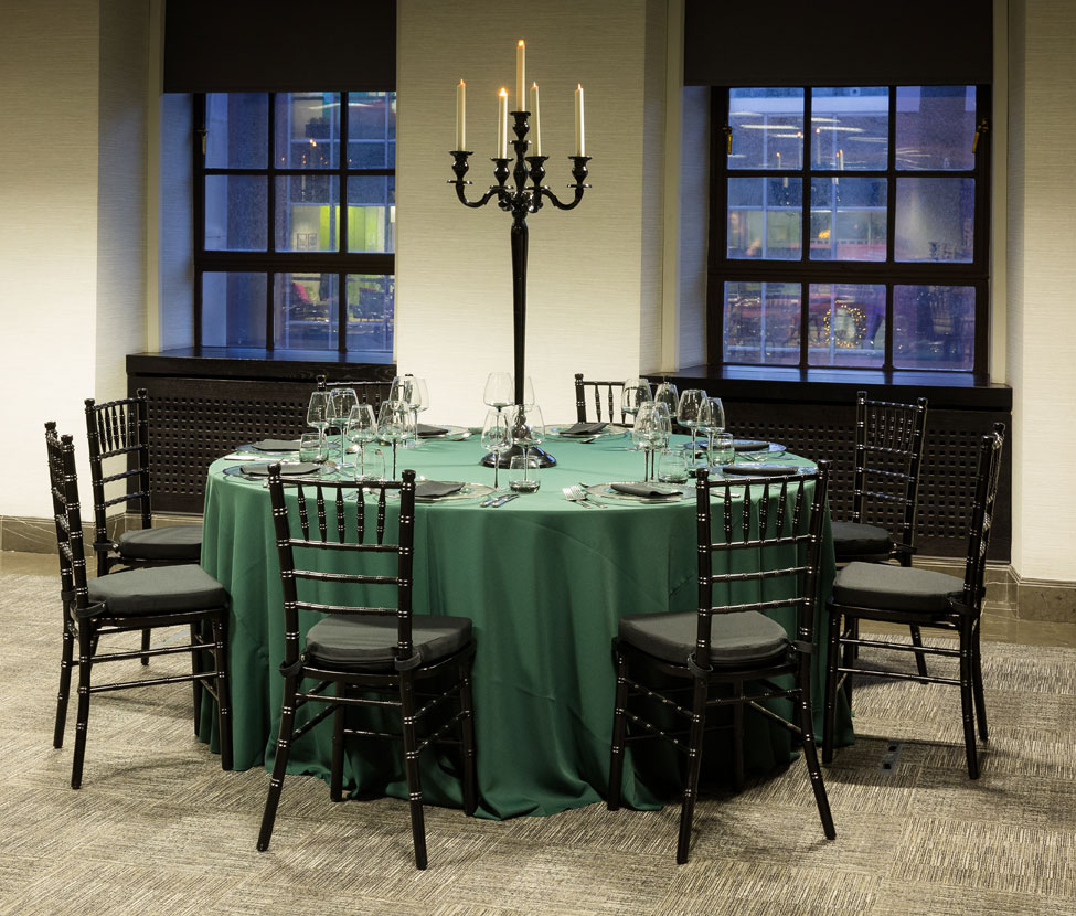 Styling featuring Green Essential table linen, Silver Trim charger plates paired with Black Essential napkins, Smoke Grey glasses, Black Gloss Candelabra and Black Chiavari Chairs with Black Essential seat pads