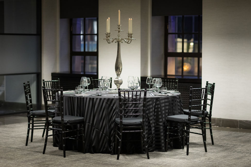 Styling featuring Black Chic table linen, Graphite Gelato napkins, Smoke Grey glasses, Silver Square Base Candelabra and Black Chiavari Chairs with Black Essential seat pads