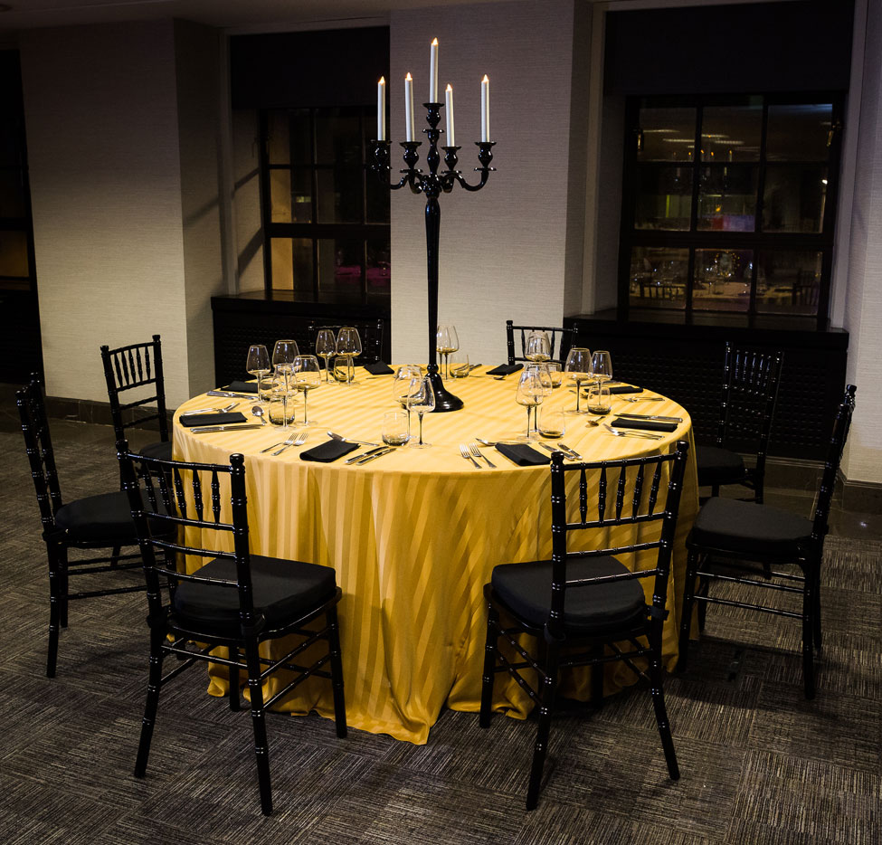Styling featuring Gold Chic table linen, Black Essential napkins, Smoke Grey glasses, Black Gloss Candelabra and Black Chiavari Chairs with Black Essential seat pads