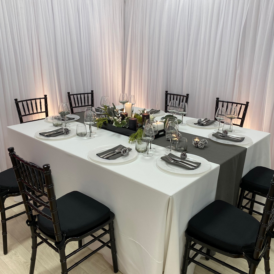 Styling features: Black Chiavari chairs w/black Essential pads, white Essential linen, graphite Gelato runner & napkins, Pearl chargers and Smoke Grey glasses.
