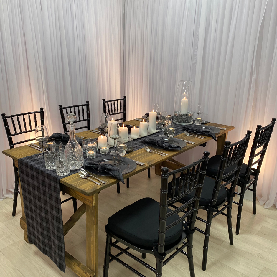 Styling features: Black Chiavari chairs w/black Essential pads, Arran tartan runner & napkins, Smoke Grey chargers & glasses.