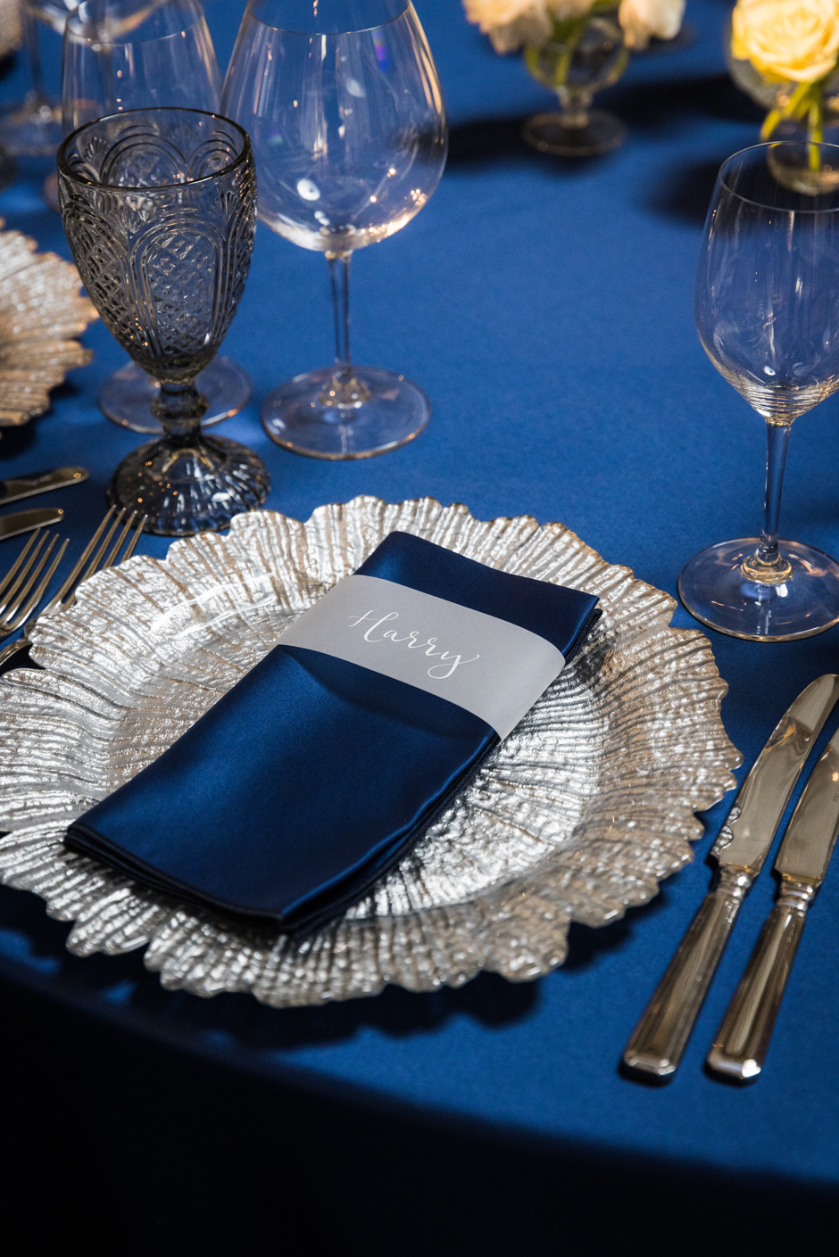 Silver petal charger plate with twilight Verona satin linen, Riedel glasses & smoke goblet