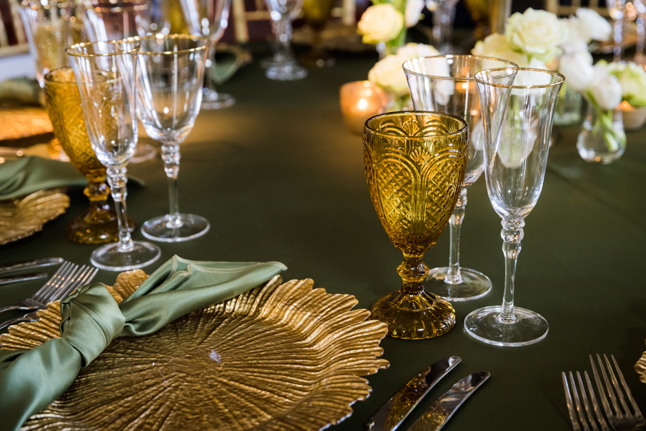 Gold trim glasses with amber goblet, moss Verona linen & gold Petal charger plate
